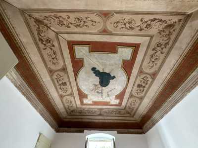 In una, alzando lo sguardo, restiamo incantati dal soffitto interamente affrescato con raffigurazioni dai colori caldi: rosso, dorato e rosa antico su uno sfondo bianco